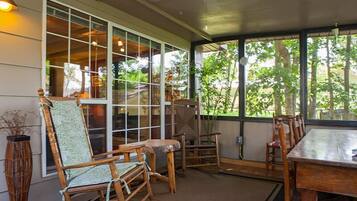 A room with a large window, wooden furniture, and a ceiling fan.