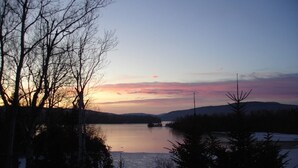 Um lago rodeado por árvores ao pôr do sol.
