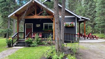 A cabin with a porch, outdoor seating, and a sign indicating a 'Golden Leaf' award.