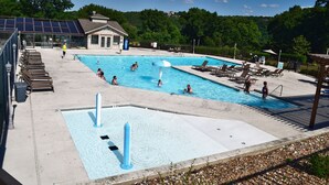 En pool med flera banor, solstolar och en liten paviljong.