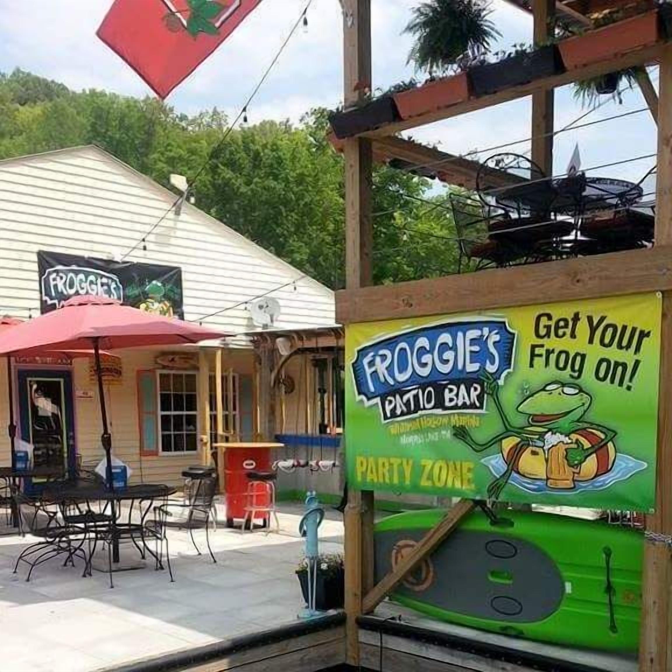 A patio area with outdoor seating and a sign for Froggie's Patio Bar.