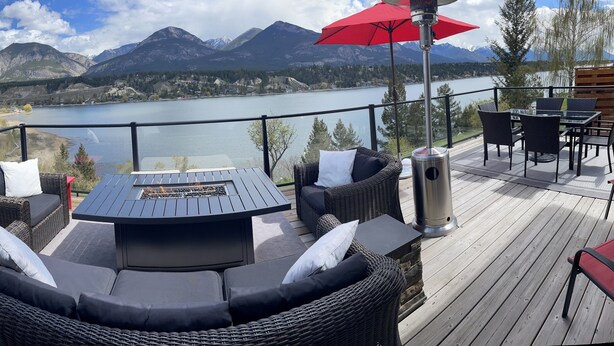 Eine Terrasse mit Korbmöbeln, einer Feuerstelle und einem Tisch mit Stühlen.