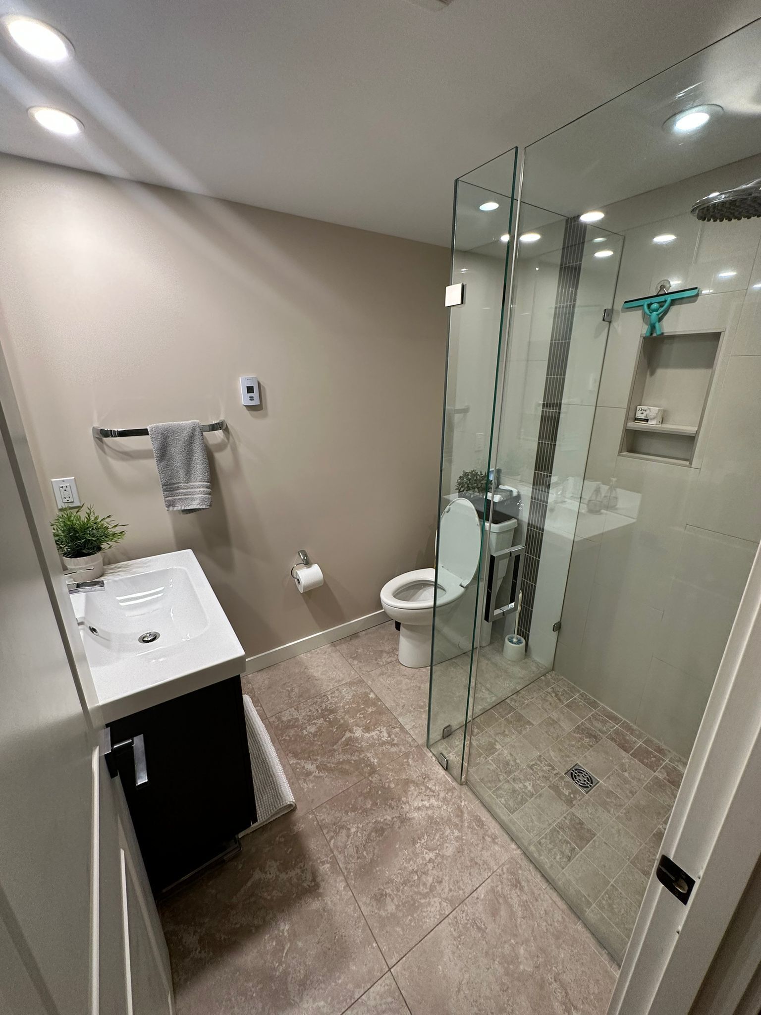 Une salle de bain moderne avec une douche à parois de verre, un lavabo et des toilettes.