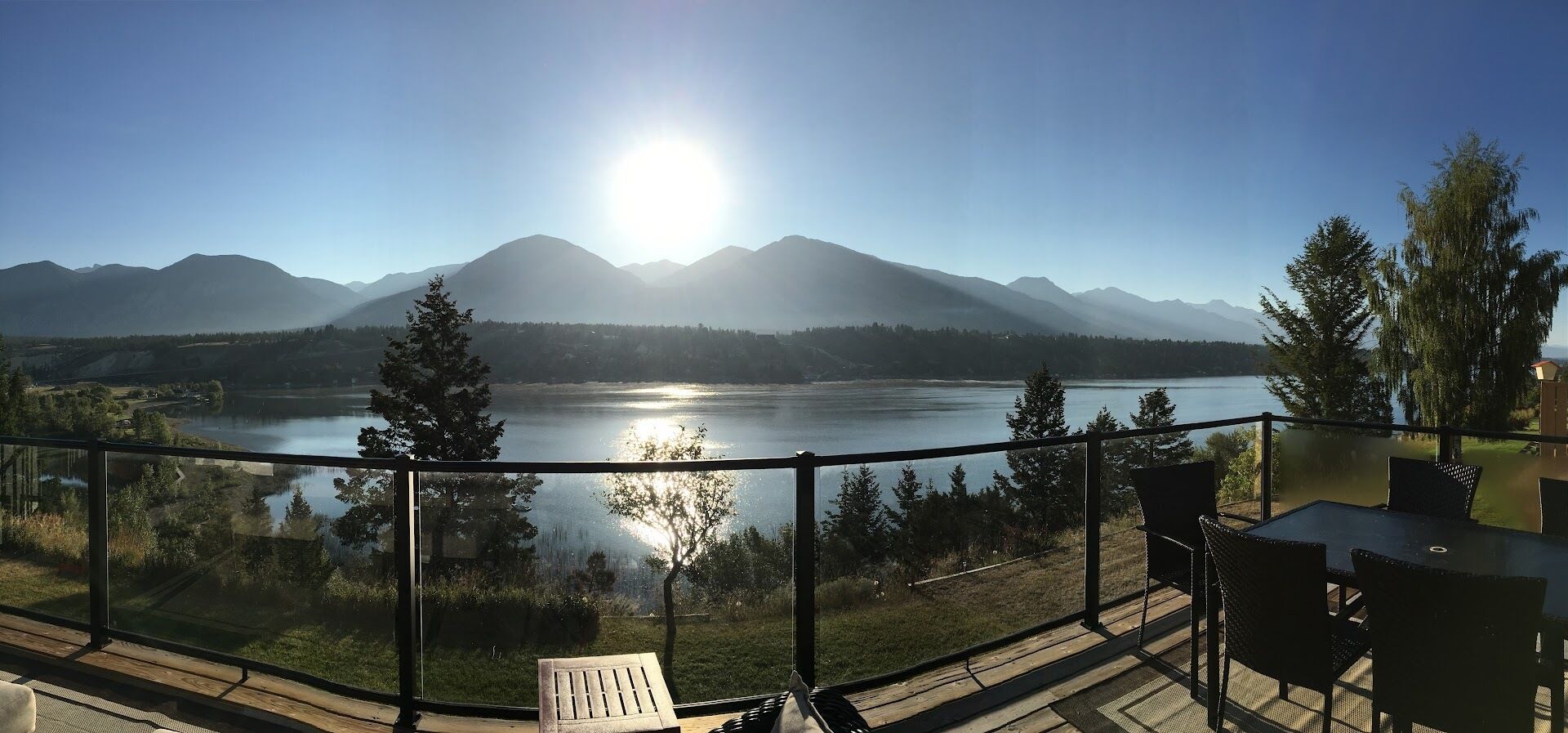 Ein Balkon mit Blick auf einen See, Berge und einen klaren Himmel.