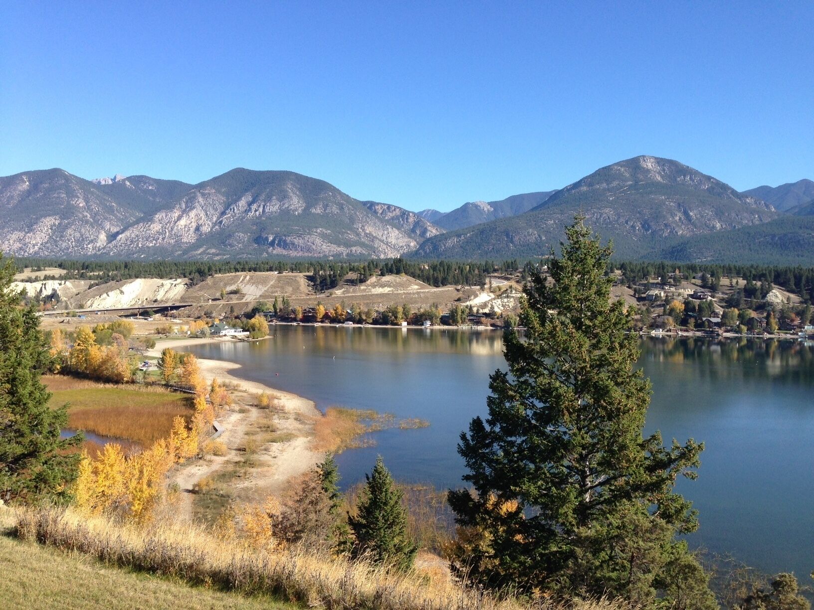 A lake surrounded by mountains, with a small town in the background.