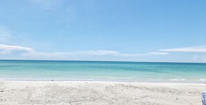 A beach with clear turquoise water and a sandy shore.
