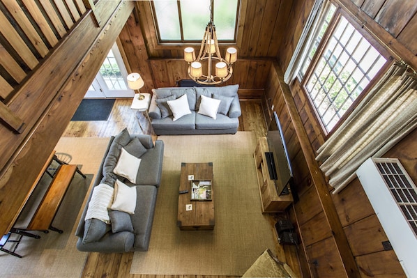 A spacious living room with a sofa set, a coffee table, and a wooden bench.