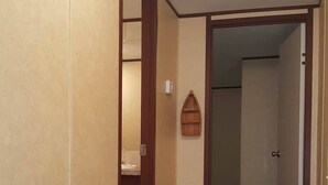 Um corredor com piso de madeira e paredes bege.