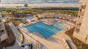 Un espace piscine avec des chaises longues et vue sur l’océan.