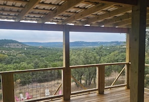 Eine Holzdielen-Terrasse mit Blick auf eine bewaldete Landschaft.
