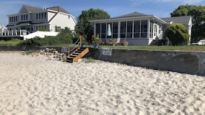 A private beach with a wooden staircase leading to a house.