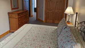A bedroom with a bed, dresser, and wardrobe.