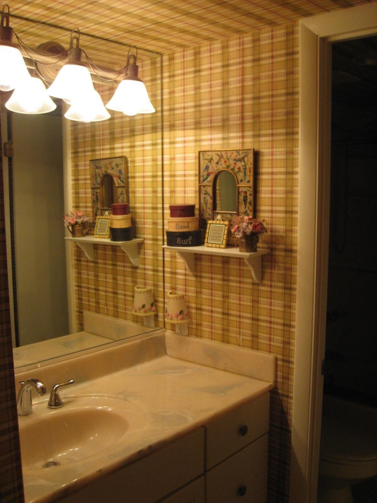 A bathroom with a sink, mirror, and shelves with toiletries.