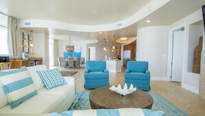 A spacious living area with a sofa, two armchairs, a coffee table, and a dining area with a table and chairs. - 4 bedroom D Tower!! Turquoise Complex (Orange Beach)