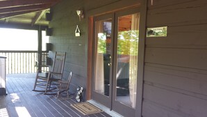 Eine Holzveranda mit Schaukelstühlen und einer Bärenfigur.