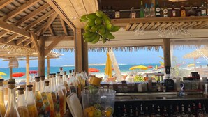 A beachside bar with a wooden ceiling, various bottles, and a view of the ocean. - Luxury Villa w Spectacular Ocean Views, private pool/Hottub, Walk to Beach (Upper Prince's Quarter)