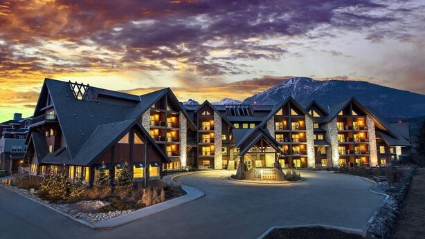 A lodge with multiple floors and a central courtyard, surrounded by mountains.