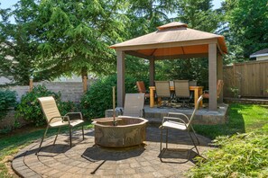 Un belvédère doté d’un foyer extérieur, de sièges pour profiter de l’extérieur et d’une terrasse entourée de verdure.