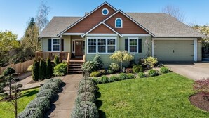 A two-story house with a front porch, a garage, and a well-maintained lawn.