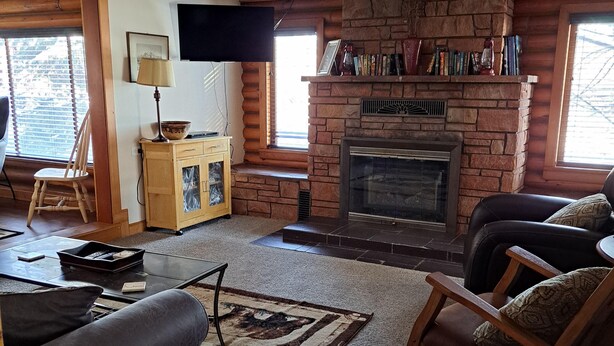 Una sala de estar acogedora con chimenea, televisor y asientos cómodos.