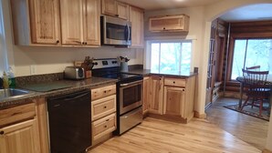 Una cocina con armarios de madera, electrodomésticos de acero inoxidable y lavavajillas.