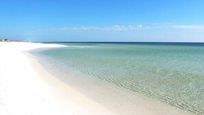 Une plage à l’eau claire et au sable blanc.