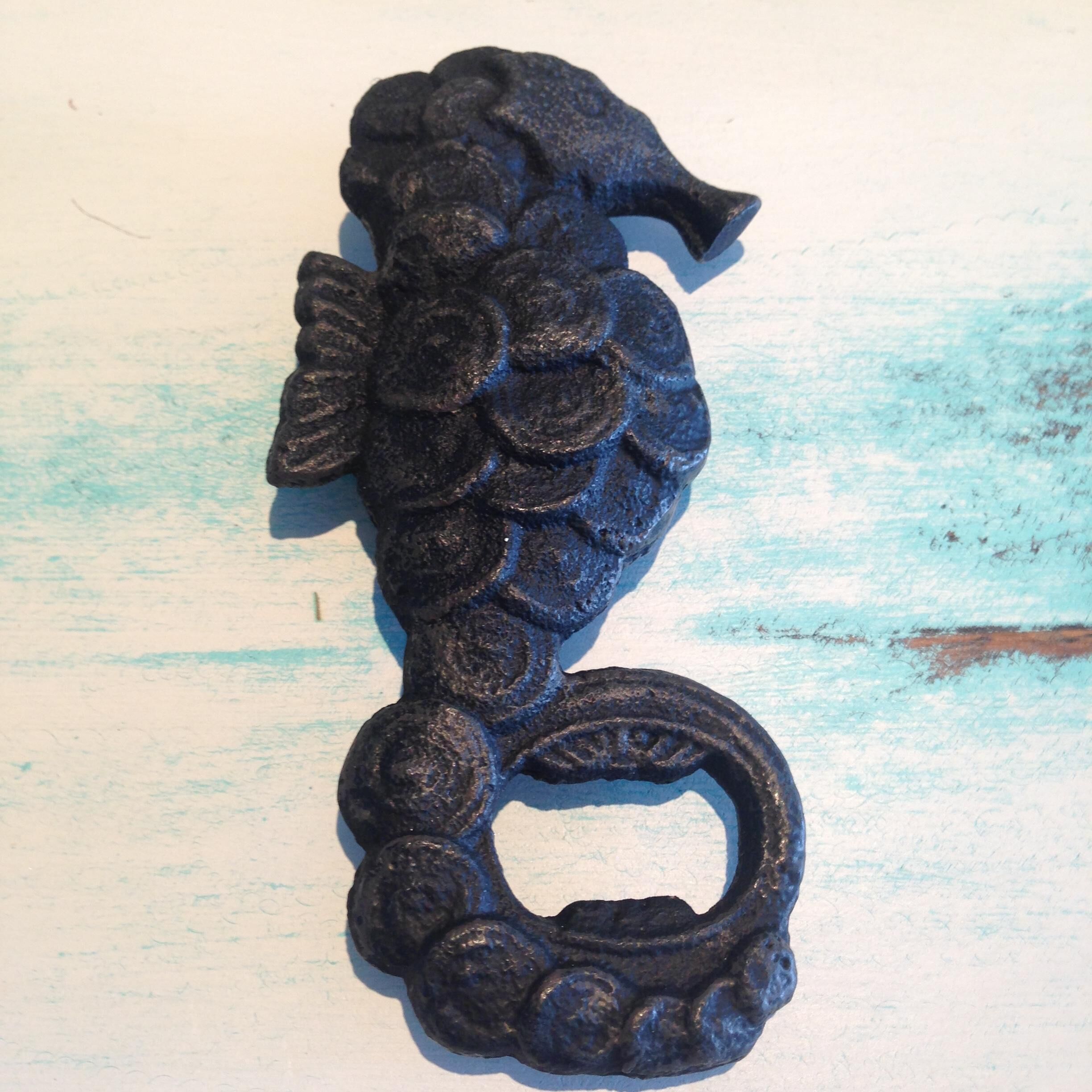 A dark, ornate metal handle with a floral design, featuring a loop at the bottom.