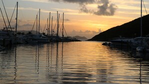 A marina with boats docked at the pier during sunset.