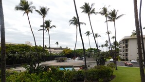 Un hotel con piscina rodeado de palmeras y follaje.