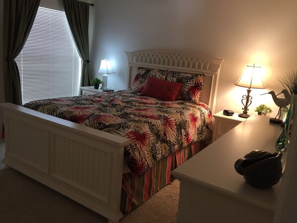 A bedroom with a bed, bedside tables, lamps, and a window with curtains. - Charming 3/2 Virginia Trace Villa, next to Lake Sumter Landing, with golf cart (The Villages)