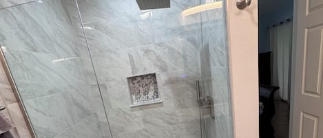 Tina con regadera, secadora de cabello, toallas, papel de baño