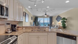 A modern kitchen with granite countertops, stainless steel appliances, and a large island with a sink. - Beachfront Condo!Beautiful View, On the Beach! Unit 308 (Destin)