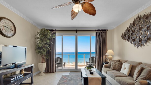 A living room with a television, a coffee table, a sofa, a large potted plant, and a view of the ocean through a sliding glass door. - Beachfront Condo!Beautiful View, On the Beach! Unit 308 (Destin)