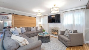 A modern living room with a sectional sofa, a round coffee table, and a fireplace.