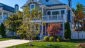 A two-story house with a front porch, a chimney, and a well-maintained lawn. - Spacious Rehoboth/Dewey Beach House Sleeps 17 (Rehoboth Beach)