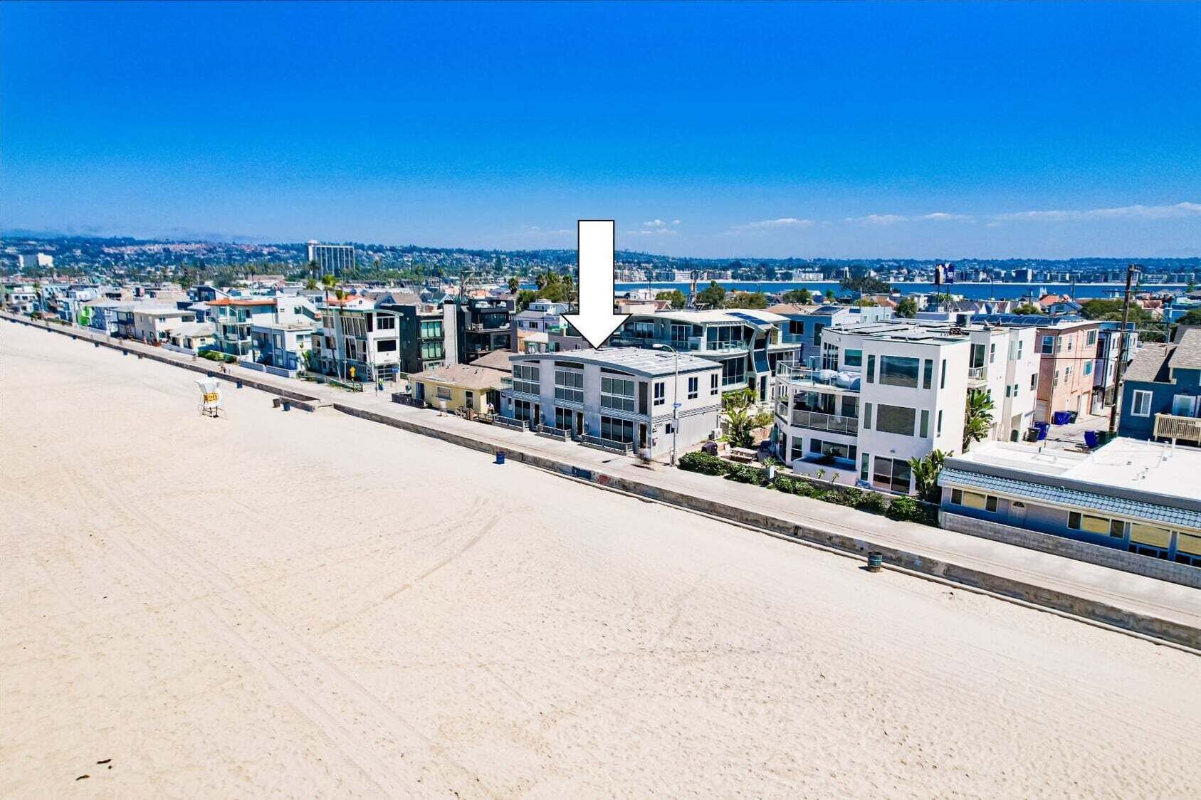 Un hotel costero de arquitectura moderna, con vistas a la playa y un cielo despejado.