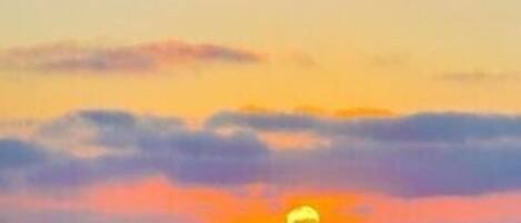 A sunset with clouds and a visible sun.
