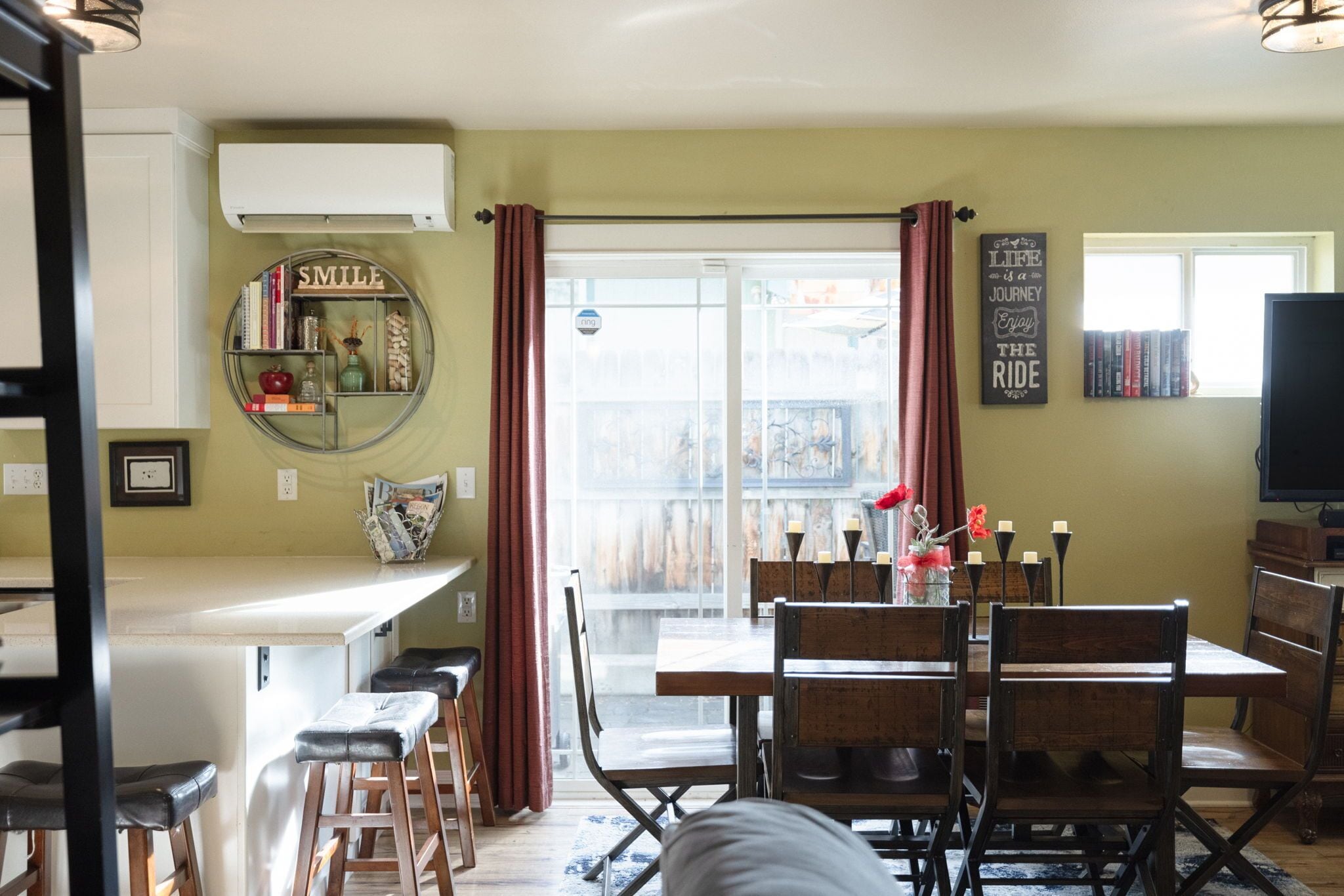 Una cocina con comedor, barra y televisor.