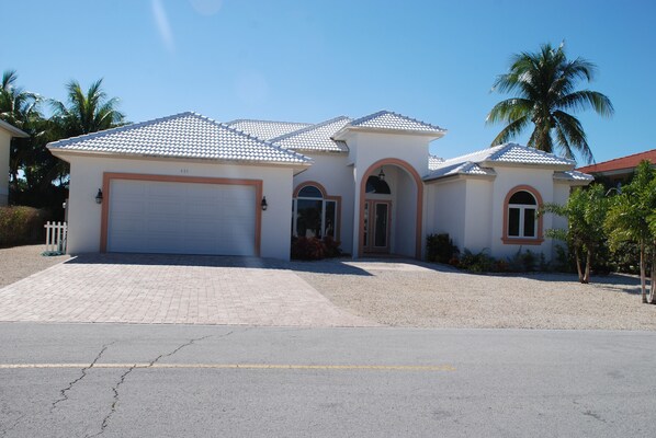 A single-story house with a tiled roof, a garage, and a driveway.