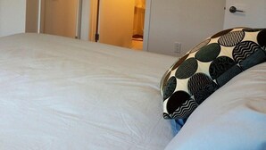 A bedroom with a bed, a door, and a framed picture on the wall. - 2 Bedroom Apt RIVER & MOUNTAIN VIEWS , IN THE HEART OF WHITEHORSE - condo (Whitehorse)