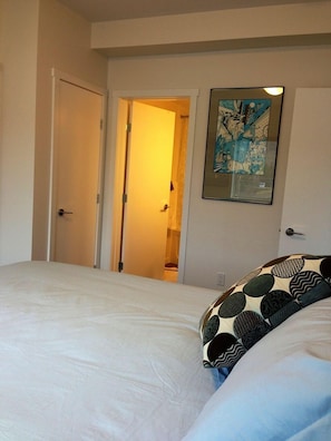 A bedroom with a bed, a door, and a framed picture on the wall. - 2 Bedroom Apt RIVER & MOUNTAIN VIEWS , IN THE HEART OF WHITEHORSE - condo (Whitehorse)
