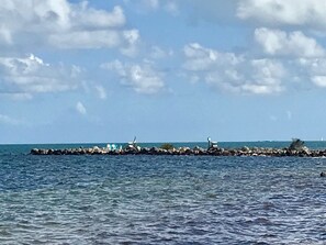 A rocky breakwater extending into the sea with a clear sky above. - Florida Keys Townhouse For Rent 2/2 (Key Largo)