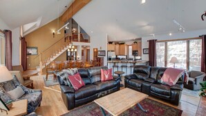 A spacious living area with leather sofas, a wooden coffee table, and a staircase leading to an upper level. - 5BR+Loft BR Home in Keystone Ski Area-pvt. hot tub; great view; 16 separate beds (Keystone)