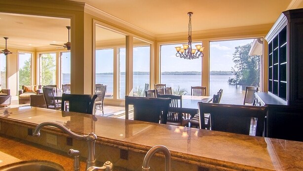 A spacious kitchen with a large island, a view of the lake, and a dining area with chairs and a table. - Lake Palestine's Best Property for Vacations, Reunions, Events, Get-Aways!!! (Frankston)