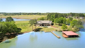 A large house with a dock and a covered area by a lake. - Lake Palestine's Best Property for Vacations, Reunions, Events, Get-Aways!!! (Frankston)