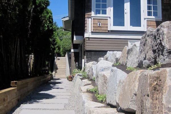 Front of home looking at pathway to suite. Suite is on the right at the flower pot.
