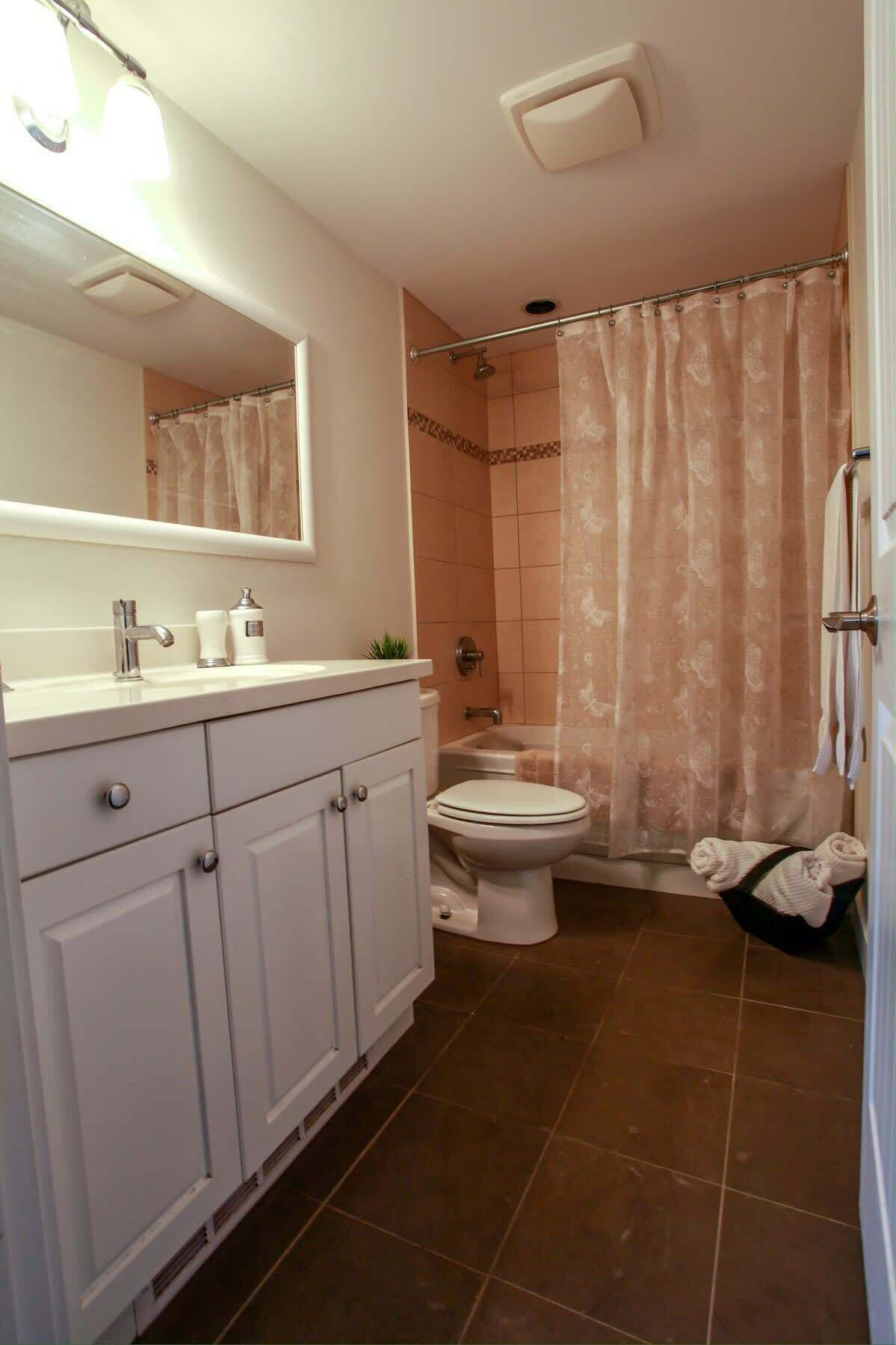A bathroom with a toilet, sink, and shower.