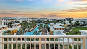 A resort with multiple buildings, a central swimming pool, and a well-maintained lawn.