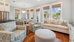 A spacious living area with a sofa, chairs, and a dining table.