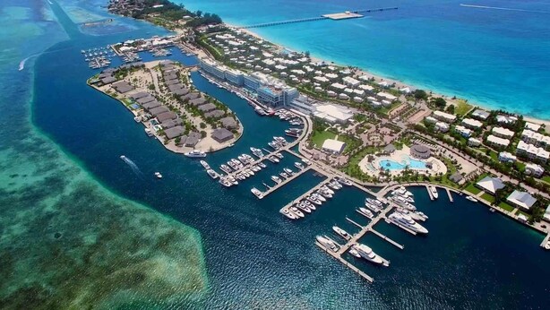 An aerial view of a coastal resort with multiple buildings, a marina, and clear blue waters. - Luxury Ocean Villa 3 Bed / 3 Bath in Bimini Bay (Bimini)